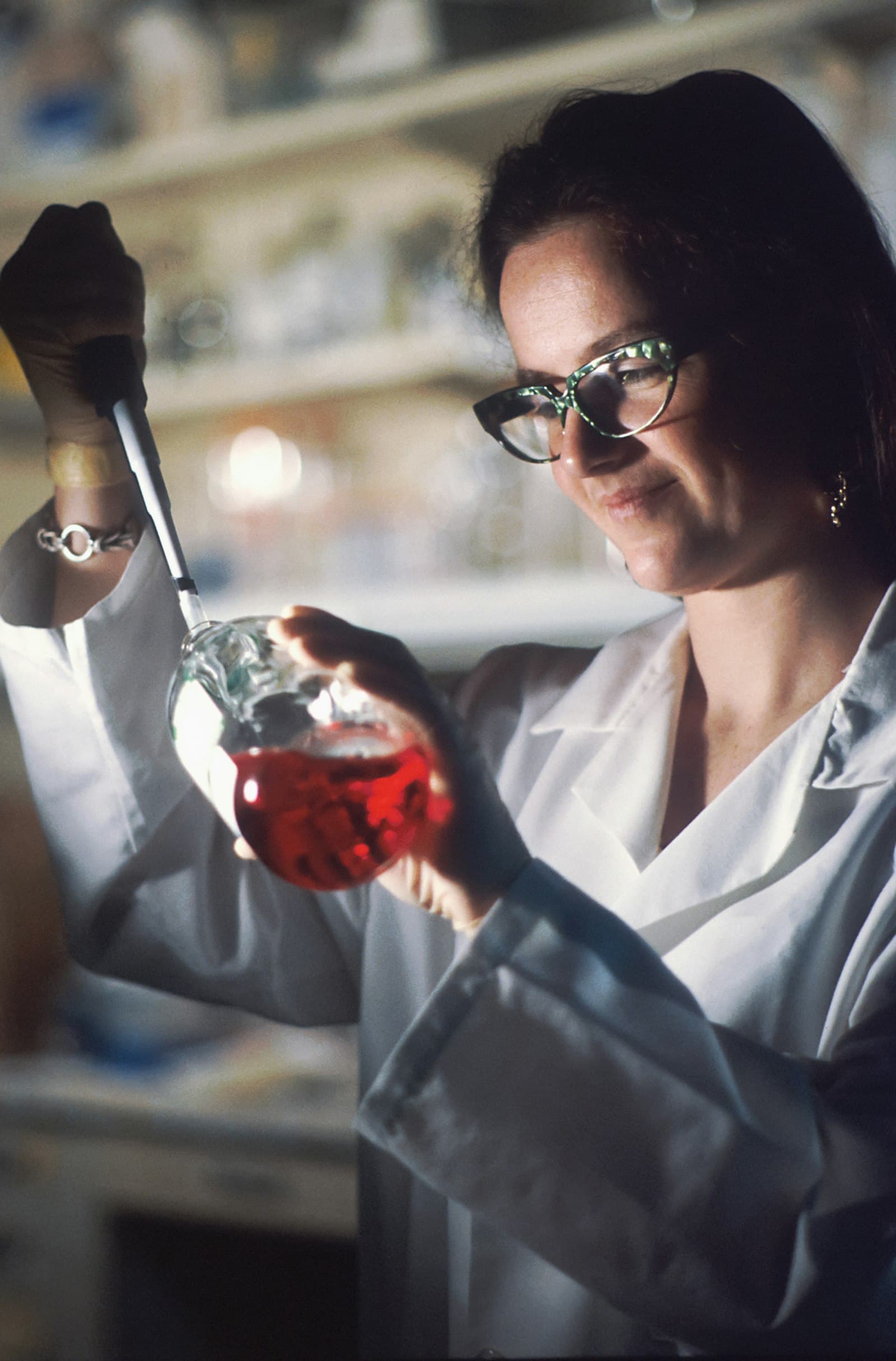 Researcher in a lab coat holding a flask in a laboratory
